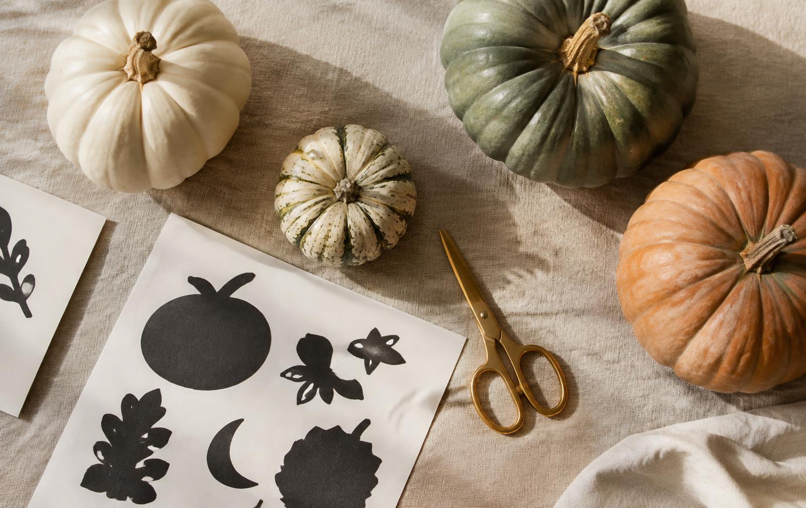 Heirloom pumpkins and stencil sheets on linen